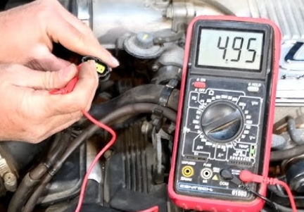 Testing 22RE throttle position sensor with multimeter showing voltage readings for Toyota pickup
